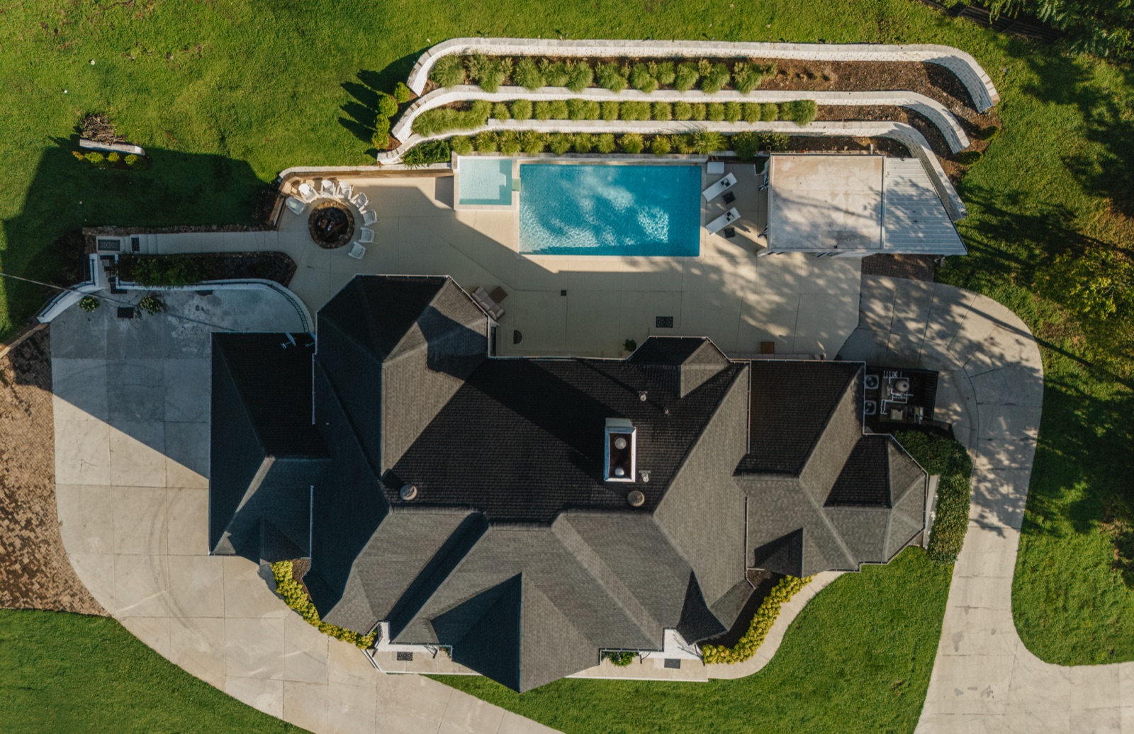The residence straight down: the full roofline, the pool and terraces, the cabana, and the motor court.