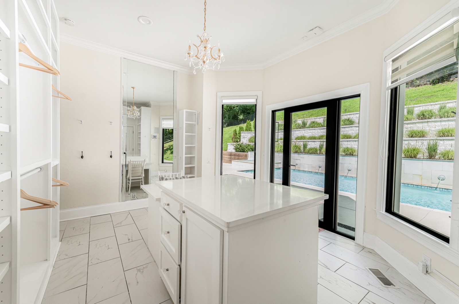 Hers: an island, a chandelier, the pool past the glass