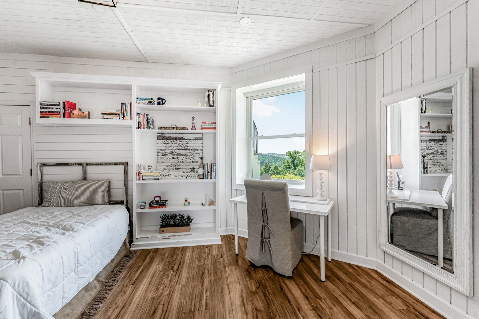 Bedroom six: shiplap walls, built-in shelving, and a desk under the window.