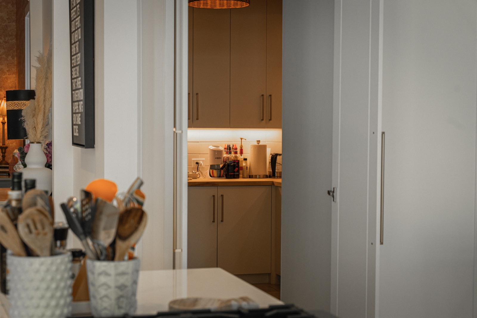 The butler's pantry's prep kitchen, lit and stocked, tucked behind the kitchen wall.